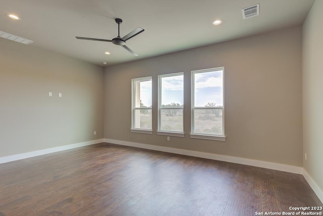 unfurnished room featuring baseboards, visible vents, dark wood-style flooring, and recessed lighting