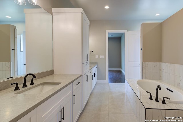 bathroom with baseboards, tile patterned floors, vanity, a bath, and recessed lighting