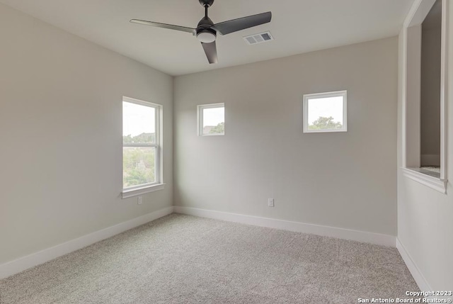 carpeted empty room with baseboards, visible vents, and ceiling fan