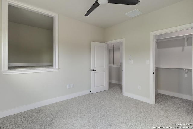 unfurnished bedroom featuring carpet floors, a spacious closet, baseboards, and a closet