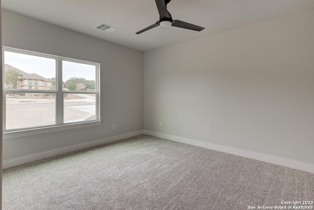 unfurnished room featuring carpet flooring, ceiling fan, visible vents, and baseboards