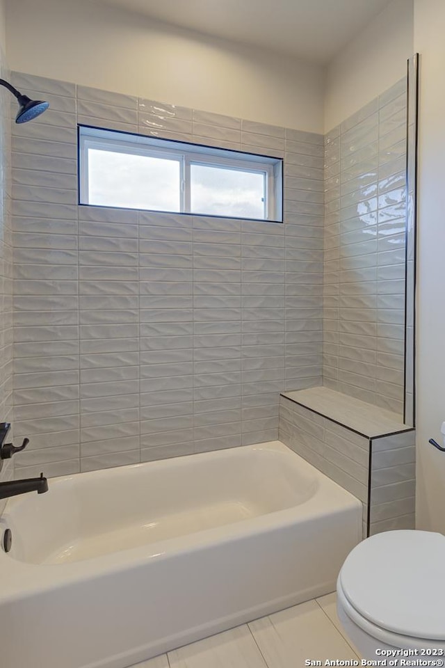 full bath featuring washtub / shower combination, toilet, and tile patterned floors