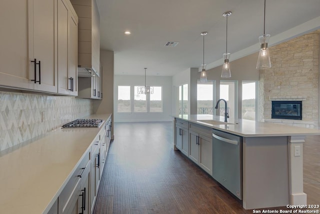 kitchen with visible vents, appliances with stainless steel finishes, open floor plan, light countertops, and a sink