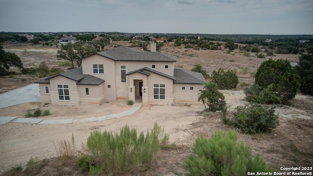 view of front of house featuring stone siding and stucco siding