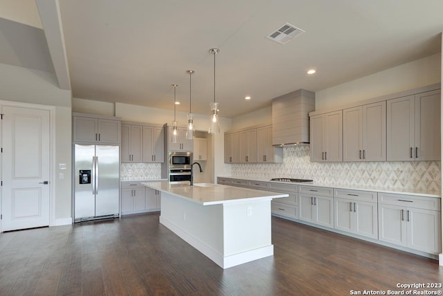 kitchen with stainless steel appliances, premium range hood, a sink, visible vents, and light countertops