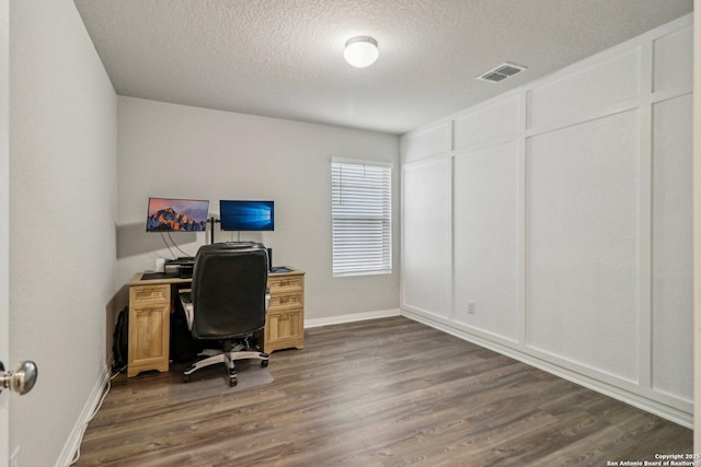 office with dark wood-type flooring, visible vents, a textured ceiling, and baseboards