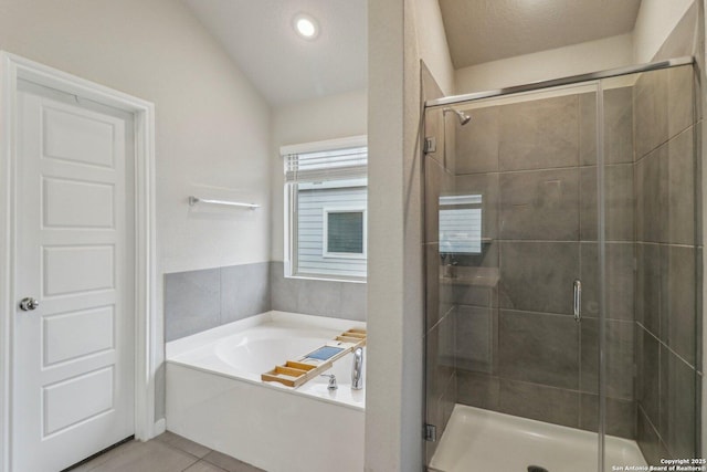 bathroom with lofted ceiling, a garden tub, tile patterned flooring, and a stall shower