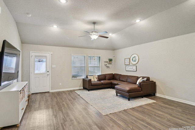 living area featuring ceiling fan, vaulted ceiling, baseboards, and wood finished floors