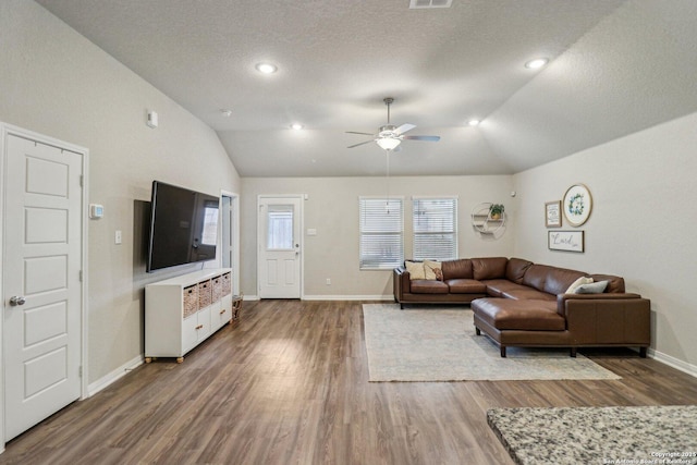 living area featuring baseboards, vaulted ceiling, and wood finished floors