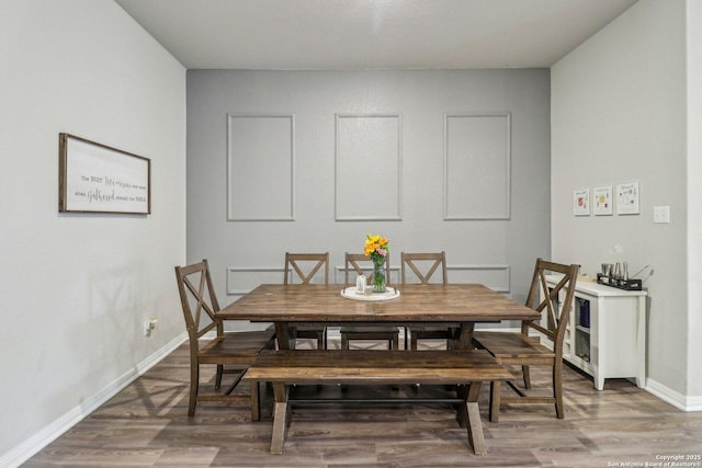 dining area featuring baseboards and wood finished floors