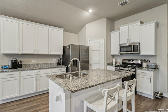 kitchen with visible vents, appliances with stainless steel finishes, dark wood-type flooring, white cabinets, and a sink