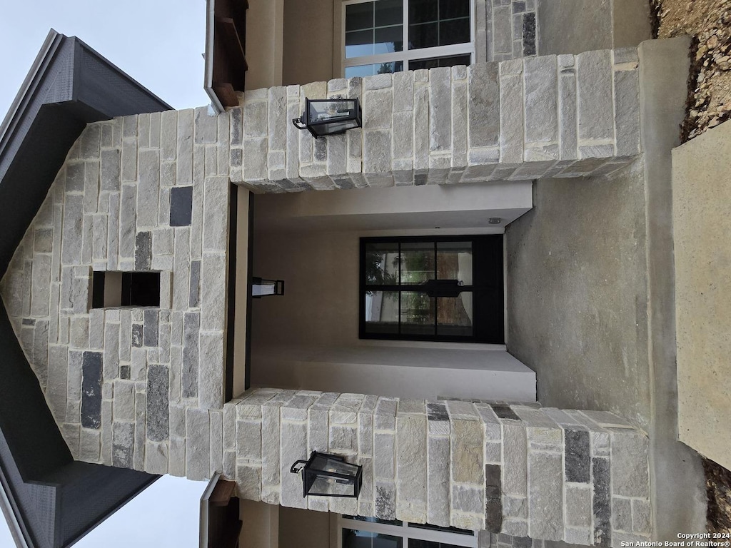 exterior space featuring stone siding and stucco siding