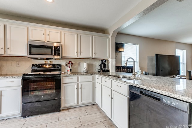 215 Quince Flower, San Antonio, TX 78253 - kitchen featuring decorative backsplash, dishwashing machine, stainless steel microwave, black range with electric stovetop, and a sink