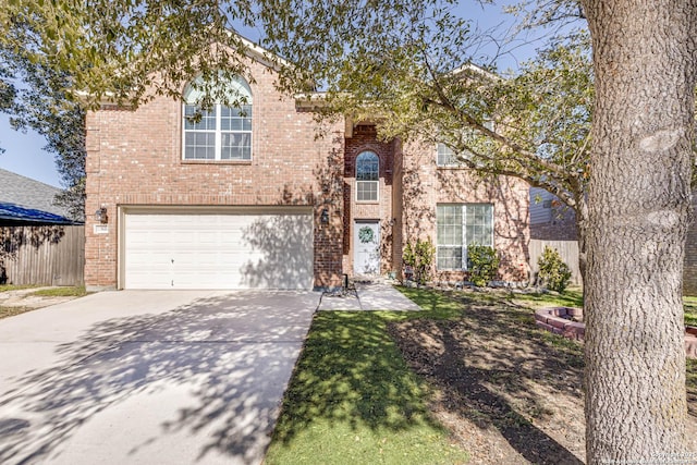 traditional home featuring a garage, concrete driveway, brick siding, and fence