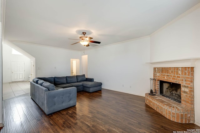 living room featuring crown molding, a fireplace, ceiling fan, wood finished floors, and baseboards