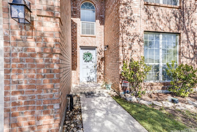 view of exterior entry featuring brick siding