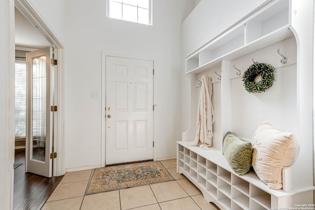 mudroom featuring tile patterned flooring and a towering ceiling