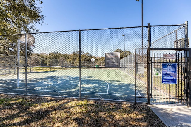 view of sport court with community basketball court, fence, and a gate