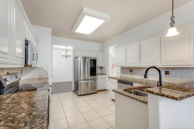 kitchen featuring light tile patterned floors, dark stone counters, appliances with stainless steel finishes, crown molding, and pendant lighting