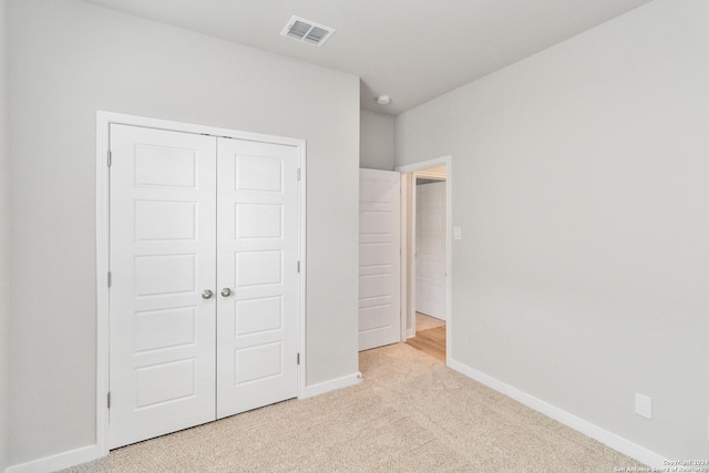 unfurnished bedroom featuring a closet, carpet flooring, visible vents, and baseboards