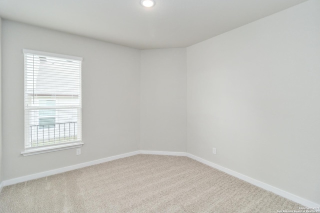 spare room with recessed lighting, baseboards, and light colored carpet