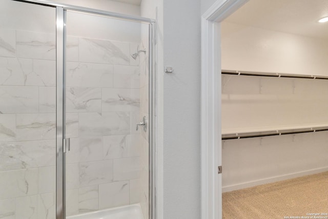 full bathroom featuring a shower stall and a spacious closet