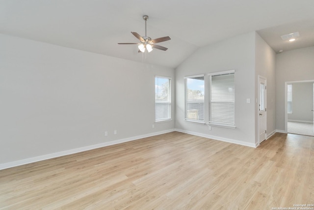 unfurnished room featuring lofted ceiling, light wood finished floors, ceiling fan, and baseboards