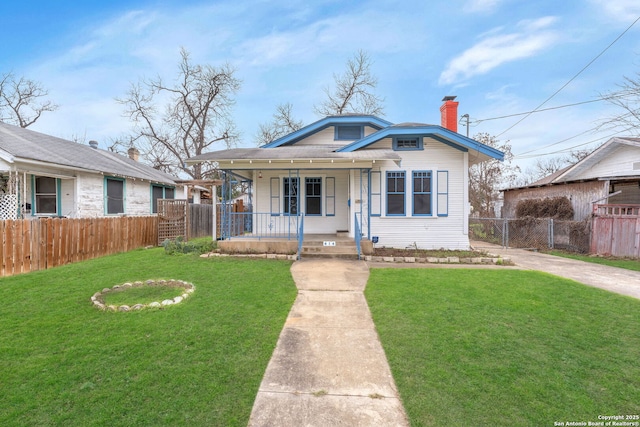 bungalow-style home featuring a porch, a front lawn, a chimney, and fence