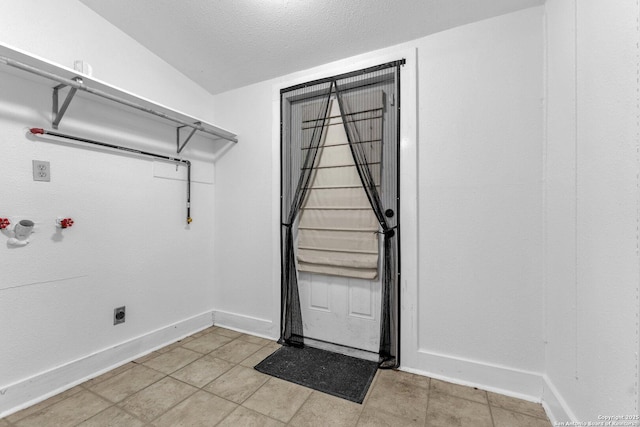 laundry room featuring washer hookup, laundry area, a textured ceiling, and baseboards