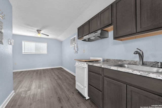 kitchen with light countertops, white gas stove, under cabinet range hood, and a sink