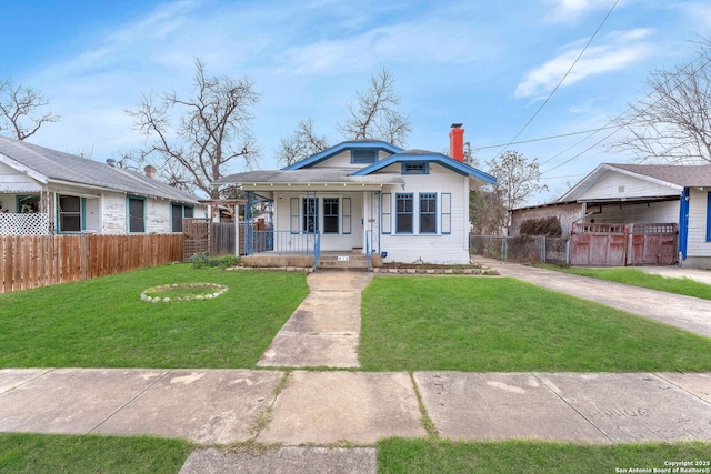 bungalow-style house featuring a chimney, covered porch, concrete driveway, fence, and a front lawn