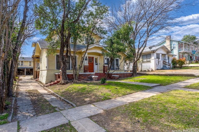 view of front facade featuring a front yard, brick siding, and a residential view