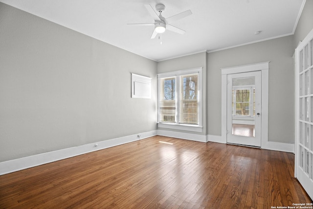 empty room with ornamental molding, a ceiling fan, hardwood / wood-style flooring, and baseboards