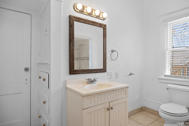 bathroom featuring a wealth of natural light, vanity, toilet, and tile patterned floors