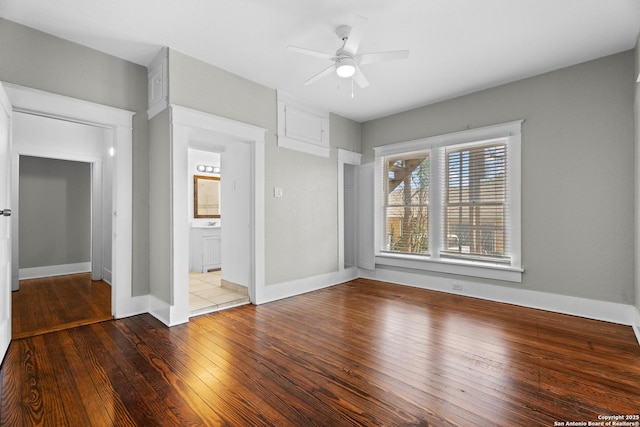 unfurnished bedroom with hardwood / wood-style flooring, baseboards, a ceiling fan, and ensuite bathroom