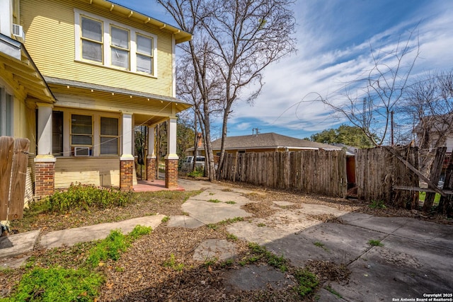 view of yard featuring covered porch and fence