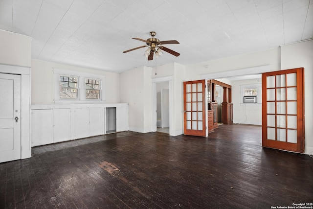 unfurnished living room featuring plenty of natural light, dark wood finished floors, a ceiling fan, and french doors