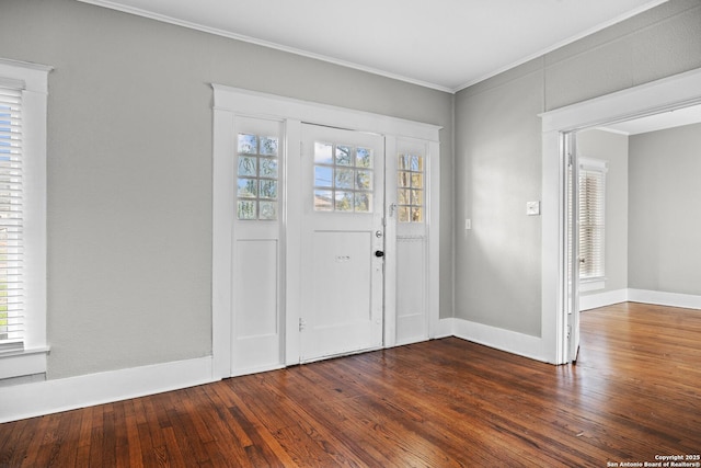 foyer entrance featuring baseboards, wood-type flooring, and crown molding