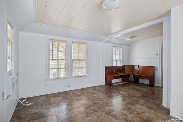 interior space featuring stone finish flooring and vaulted ceiling