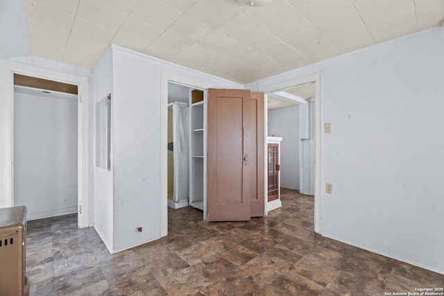 unfurnished bedroom with baseboards, stone finish floor, and a closet