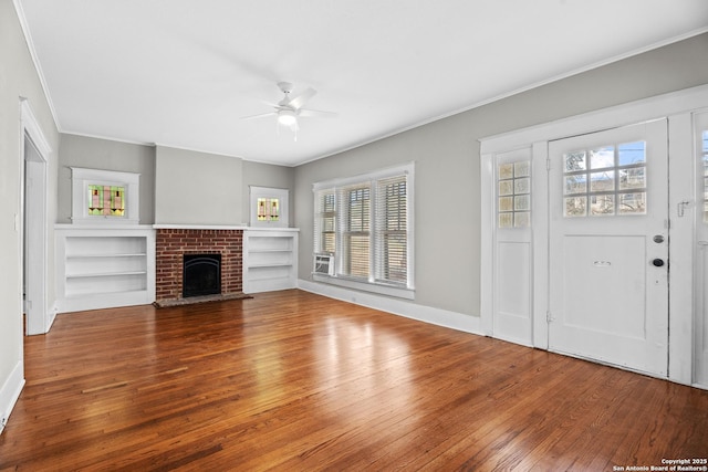 unfurnished living room with ceiling fan, a brick fireplace, crown molding, and hardwood / wood-style flooring