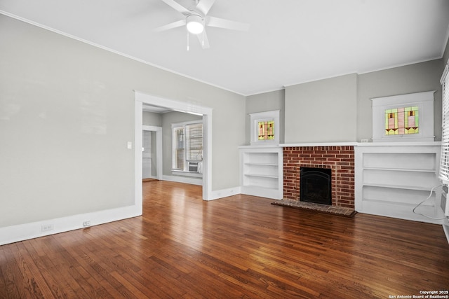 unfurnished living room featuring baseboards, ceiling fan, hardwood / wood-style floors, crown molding, and a brick fireplace