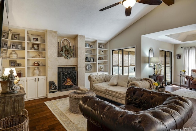 living room featuring vaulted ceiling, dark wood-style flooring, a fireplace, and a wealth of natural light