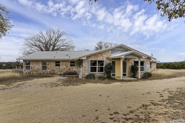 view of front facade with stone siding and metal roof