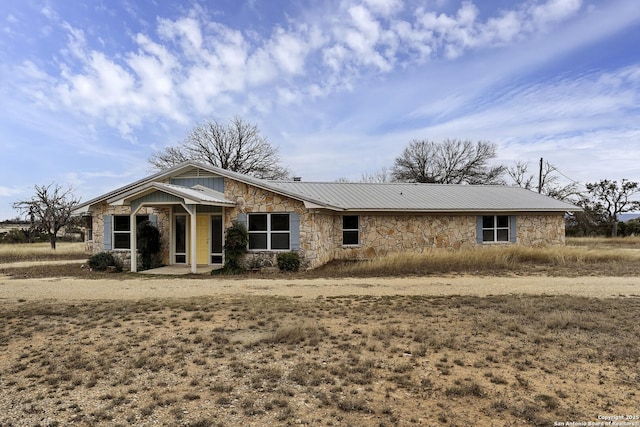 view of front of home featuring stone siding and metal roof