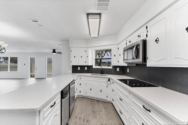 kitchen with white cabinetry, appliances with stainless steel finishes, decorative backsplash, and a sink