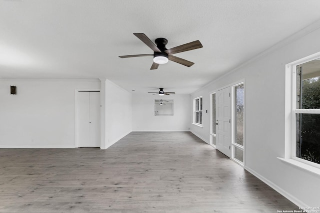 spare room with baseboards, wood finished floors, and crown molding