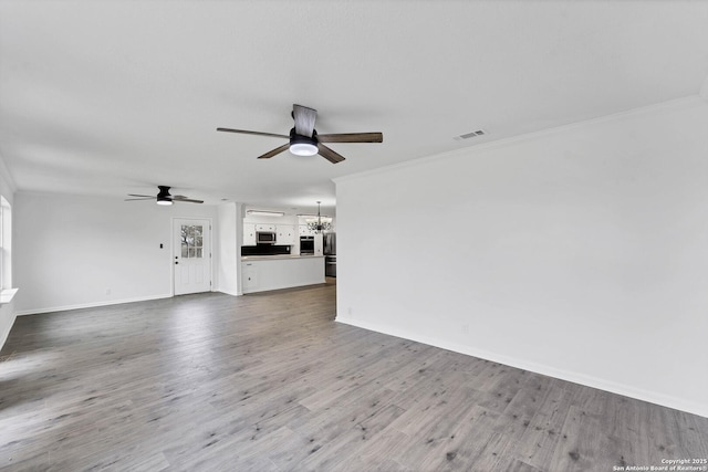 unfurnished living room with baseboards, visible vents, ornamental molding, wood finished floors, and ceiling fan with notable chandelier