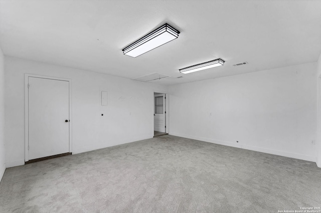 carpeted spare room with attic access and visible vents