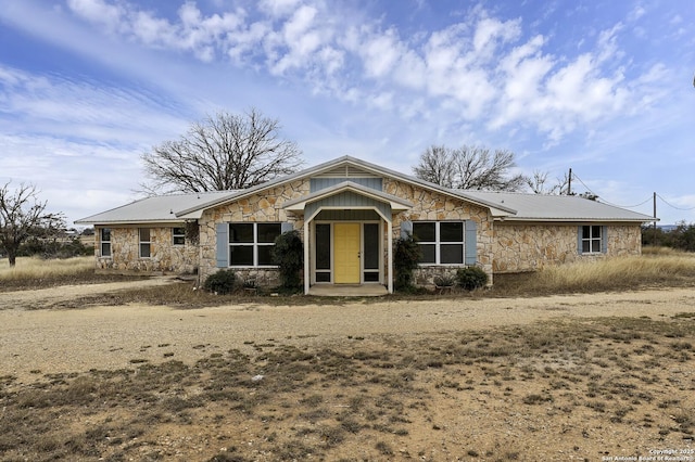 view of front facade with stone siding and metal roof